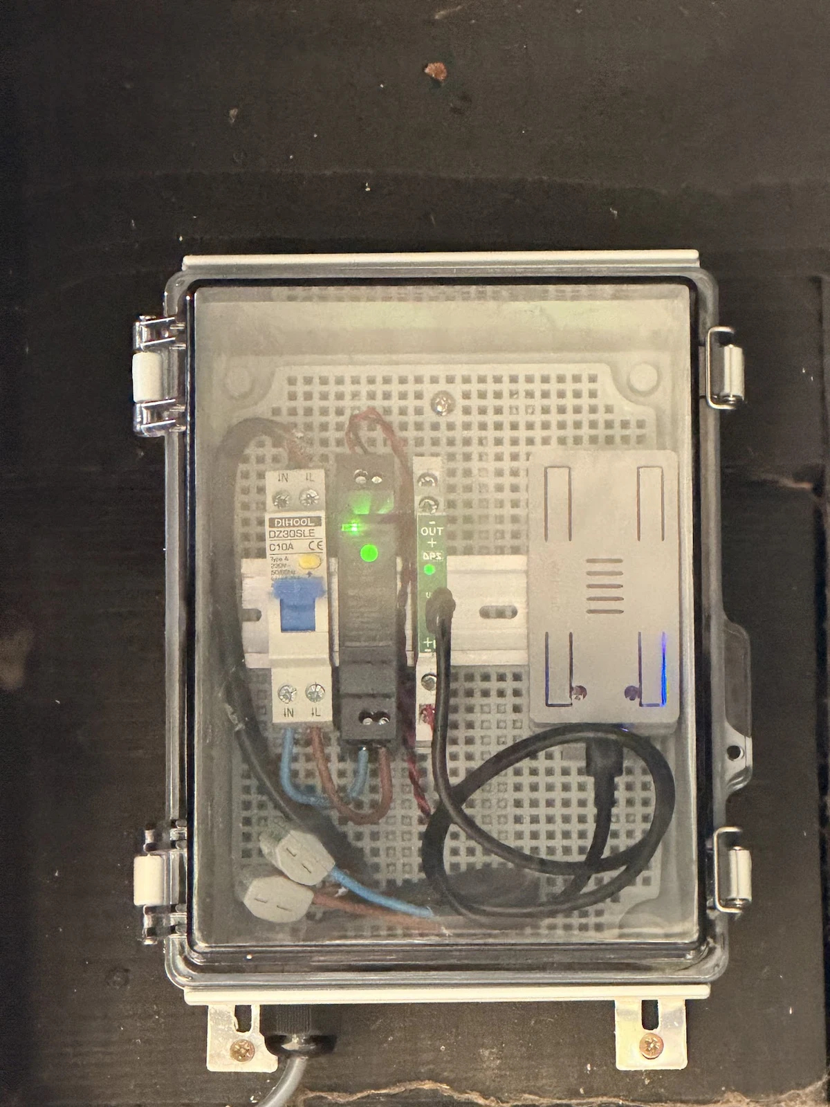 The installed BinRange anchor and power components inside a clear-lidded wall enclosure.